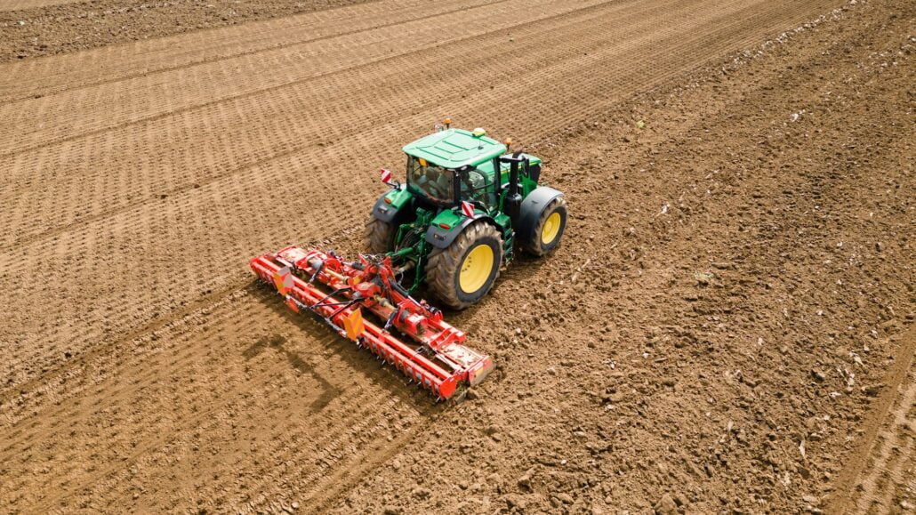 A picture of a rural farming community showcasing the use of farming machinery and equipment, such