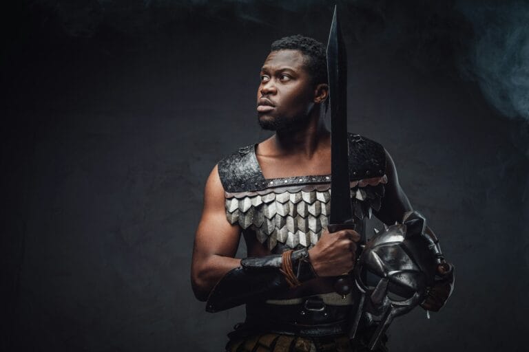 Authentic roman gladiator stares to camera on gray background