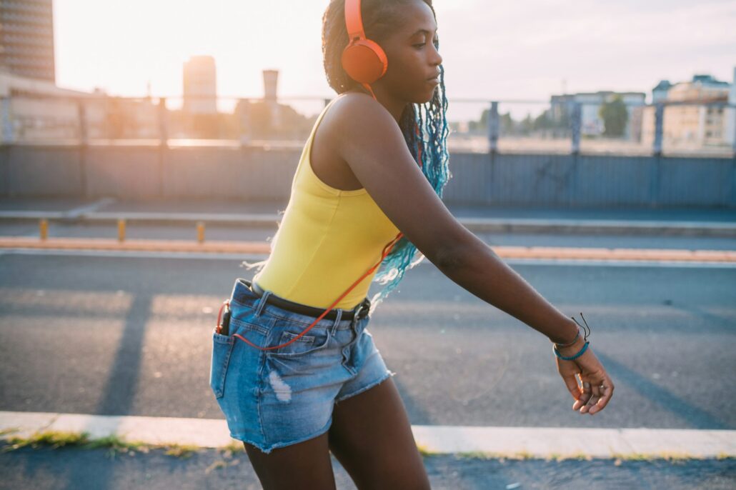 young black beautiful woman outdoor listening music dancing