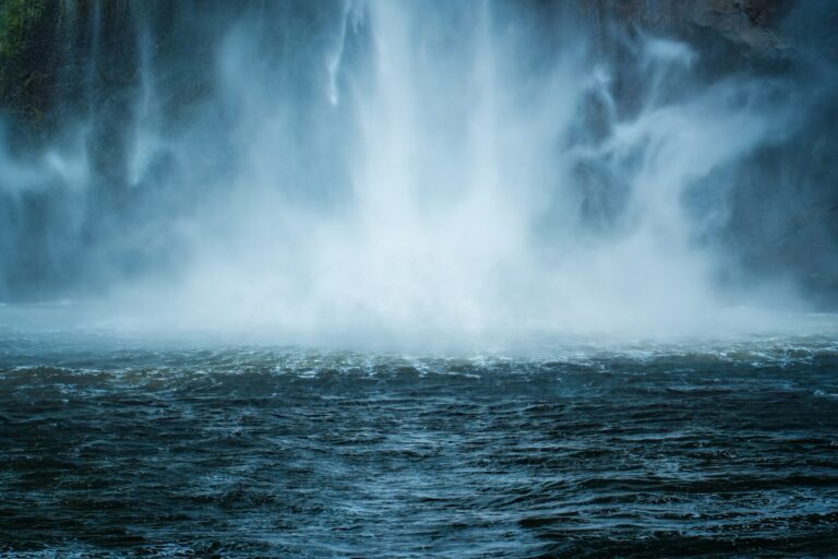 Moody waterfall flowing in tropical rainforest at Milford Sound